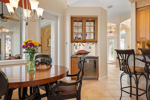 tiled dining room featuring a notable chandelier