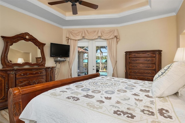 bedroom with ceiling fan, access to exterior, wood-type flooring, a tray ceiling, and ornamental molding