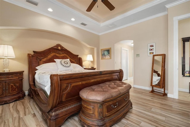 bedroom featuring ceiling fan, crown molding, a raised ceiling, and light hardwood / wood-style floors