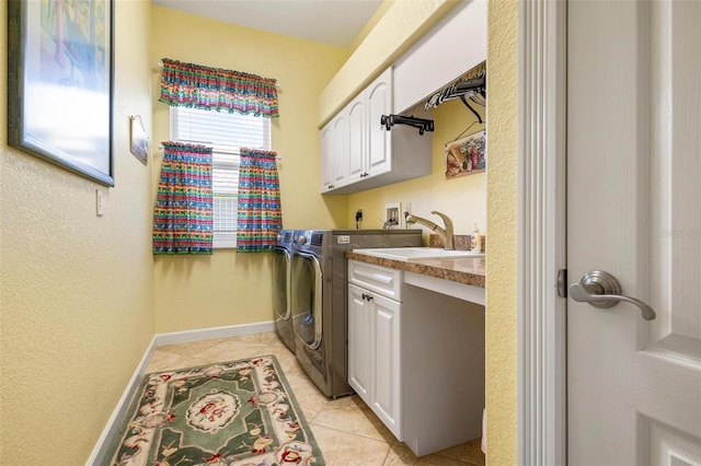 laundry room with sink, independent washer and dryer, cabinets, and light tile patterned floors