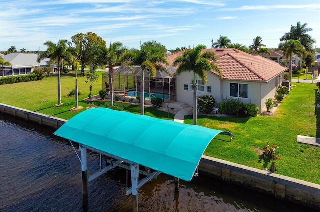 exterior space featuring a water view, glass enclosure, and a yard