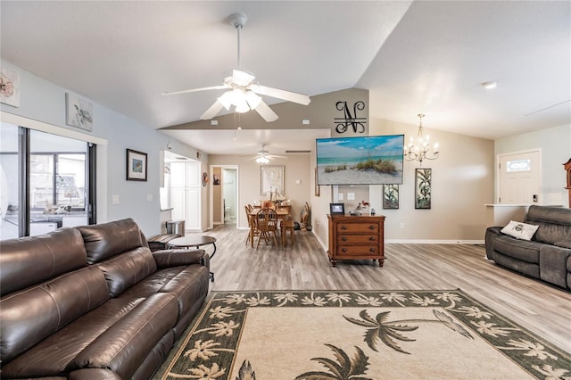 living room with hardwood / wood-style flooring, ceiling fan with notable chandelier, and vaulted ceiling