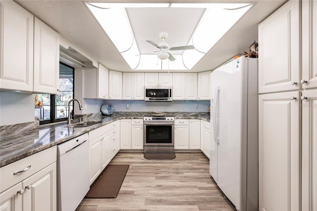 kitchen featuring white cabinets, ceiling fan, appliances with stainless steel finishes, light wood-type flooring, and sink