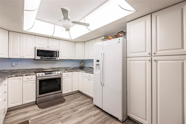 kitchen with white cabinets, stainless steel appliances, light wood-type flooring, and ceiling fan