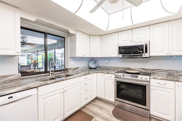 kitchen with stone counters, sink, light hardwood / wood-style floors, stainless steel appliances, and white cabinets