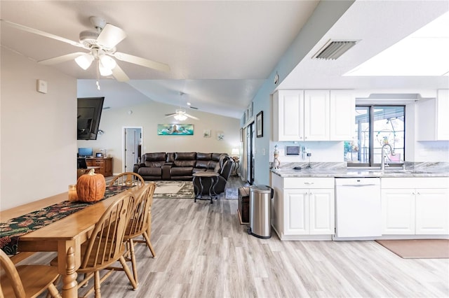 kitchen with lofted ceiling, white cabinets, light stone countertops, dishwasher, and light hardwood / wood-style floors