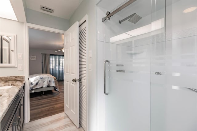 bathroom featuring vanity, ceiling fan, hardwood / wood-style flooring, and an enclosed shower