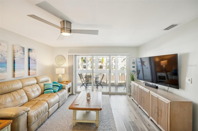 living room featuring light wood-type flooring and ceiling fan