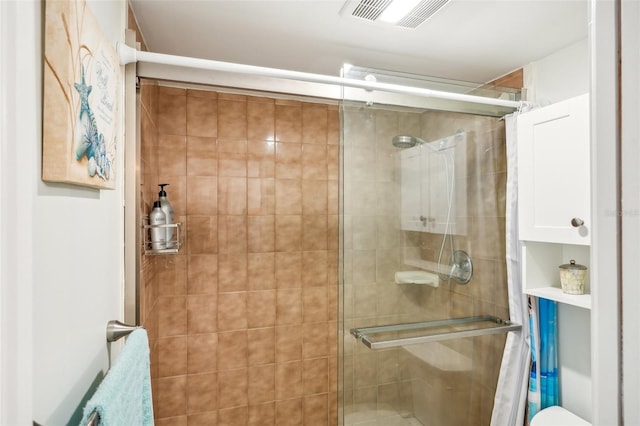 bathroom with toilet and a shower with shower door