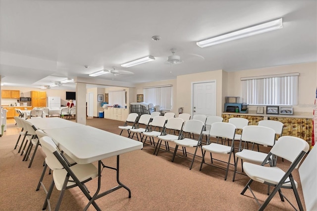 dining room with light carpet and ceiling fan