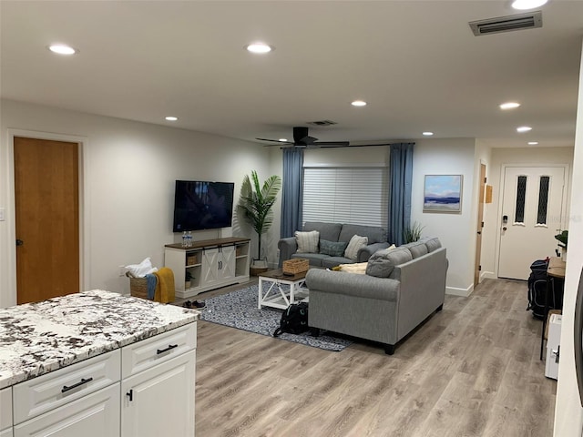 living room with ceiling fan and light hardwood / wood-style flooring