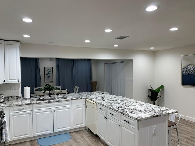 kitchen with light hardwood / wood-style flooring, kitchen peninsula, white cabinetry, and dishwasher