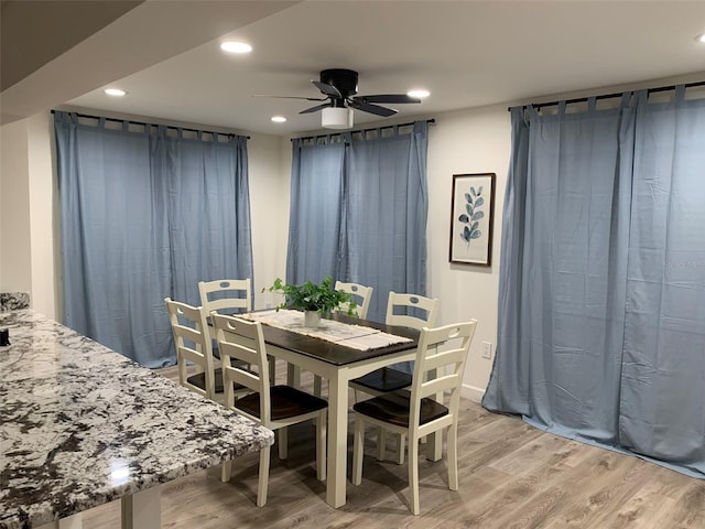 dining space featuring light wood-type flooring and ceiling fan