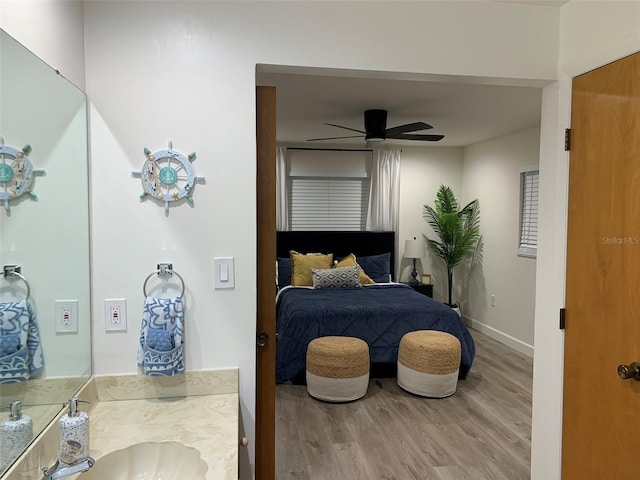 bedroom featuring ceiling fan, hardwood / wood-style flooring, and sink