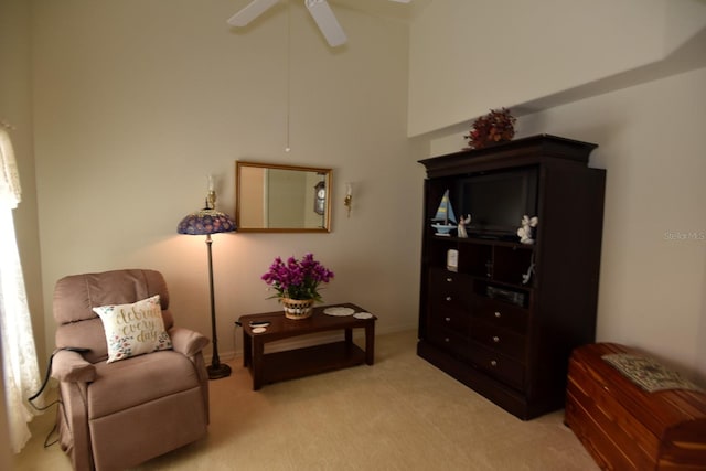 living area featuring light colored carpet and ceiling fan