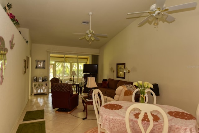 tiled dining space with ceiling fan and vaulted ceiling