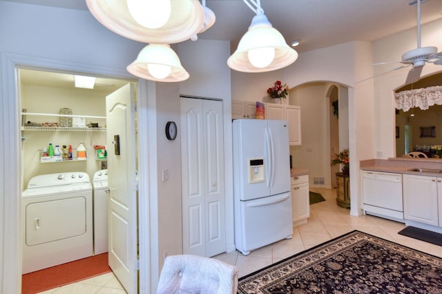 clothes washing area featuring light tile patterned floors, washer and clothes dryer, and ceiling fan