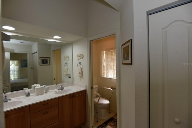 bathroom with vanity, toilet, and a healthy amount of sunlight