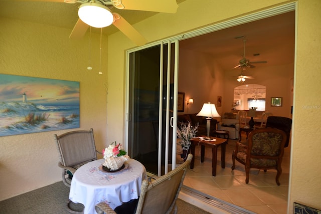 dining area featuring ceiling fan and tile patterned flooring