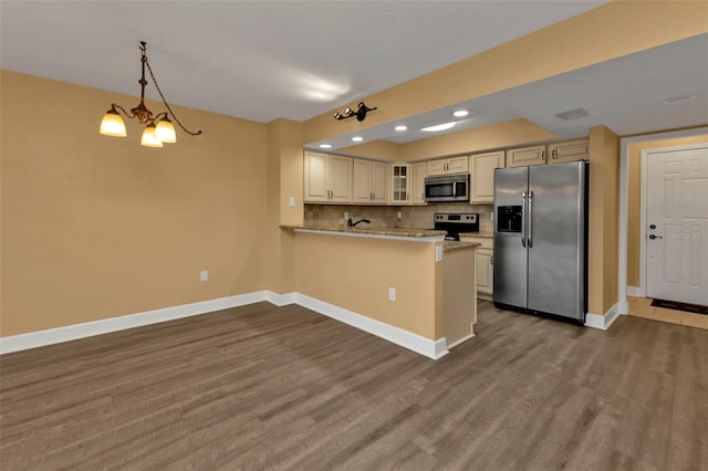 kitchen featuring kitchen peninsula, tasteful backsplash, appliances with stainless steel finishes, pendant lighting, and light hardwood / wood-style floors