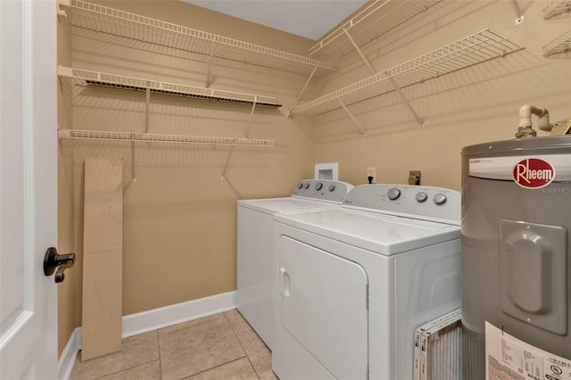 laundry area with electric water heater, washer and clothes dryer, and light tile patterned floors