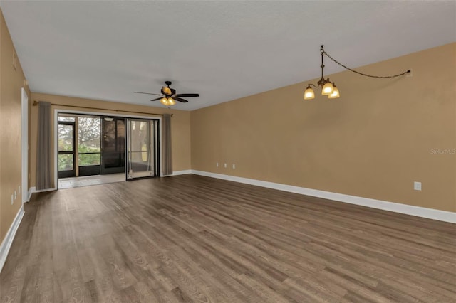 unfurnished living room featuring ceiling fan with notable chandelier and hardwood / wood-style floors