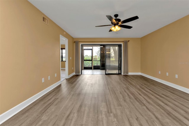 empty room with ceiling fan and light hardwood / wood-style flooring