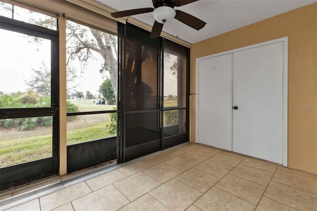 unfurnished sunroom featuring ceiling fan