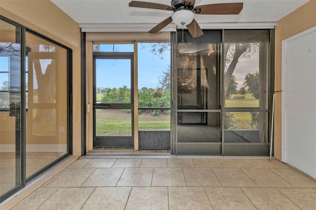 doorway to outside with ceiling fan, a textured ceiling, and light tile patterned flooring