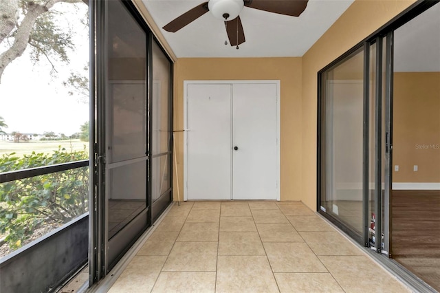 unfurnished sunroom with ceiling fan