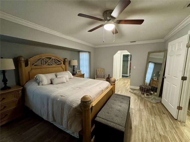 bedroom with ceiling fan, crown molding, and wood-type flooring