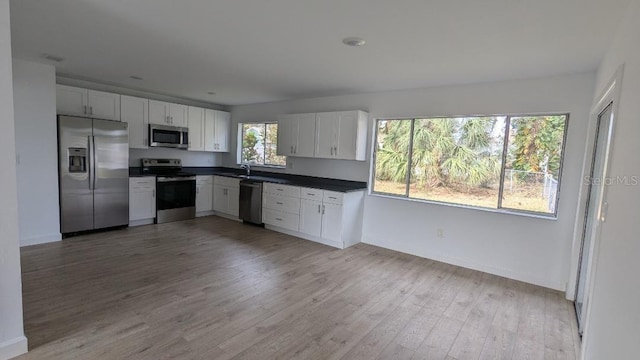 kitchen featuring white cabinetry, plenty of natural light, stainless steel appliances, and light hardwood / wood-style flooring