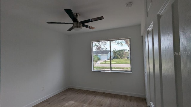 empty room with ceiling fan and light hardwood / wood-style flooring