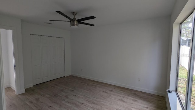 unfurnished bedroom with ceiling fan, a closet, and light hardwood / wood-style flooring