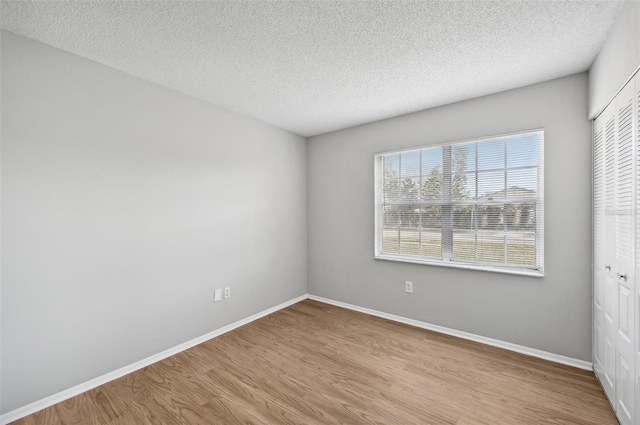 empty room featuring light hardwood / wood-style floors and a textured ceiling