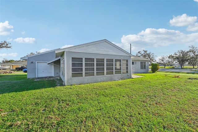 rear view of property with a yard and a garage