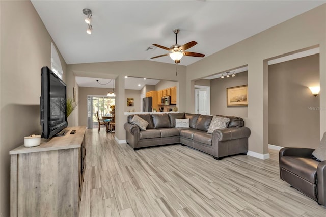 living room with light hardwood / wood-style flooring, ceiling fan with notable chandelier, and vaulted ceiling