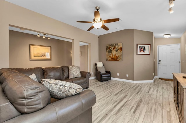 living room featuring rail lighting, ceiling fan, lofted ceiling, and light wood-type flooring