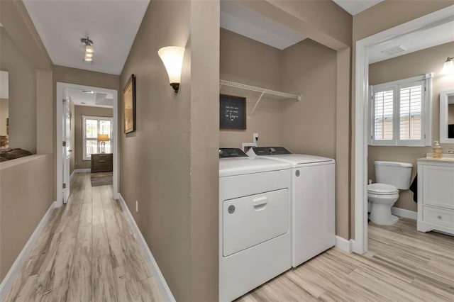 laundry room featuring washer and dryer and light hardwood / wood-style flooring