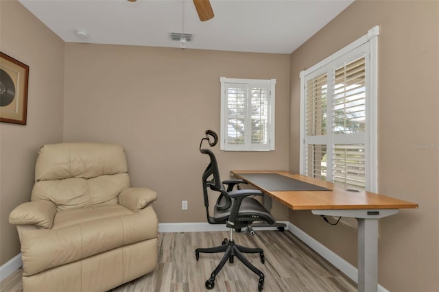 home office with light wood-type flooring and ceiling fan