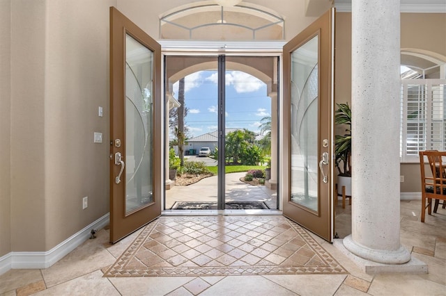 entryway featuring french doors, ornamental molding, and ornate columns