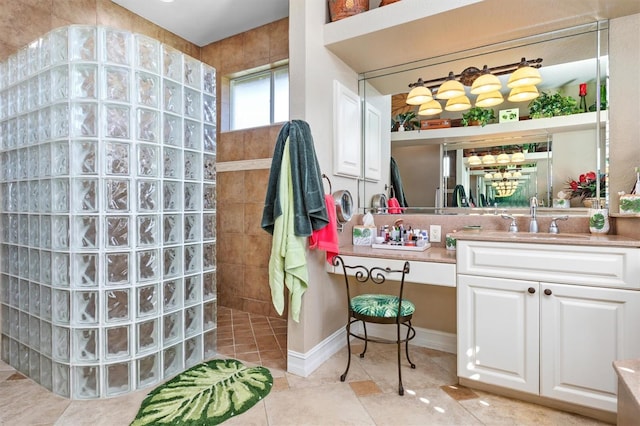 bathroom featuring vanity, tiled shower, and tile patterned flooring