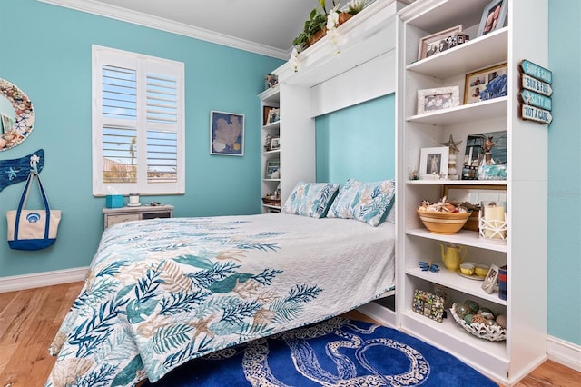 bedroom featuring ornamental molding and hardwood / wood-style floors