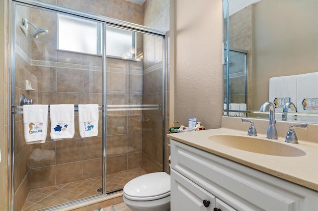 bathroom featuring vanity, a shower with shower door, and toilet