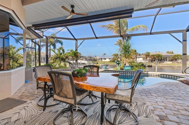 view of patio / terrace with a water view, ceiling fan, and glass enclosure