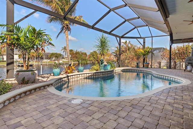 view of swimming pool featuring ceiling fan, a patio, and a lanai