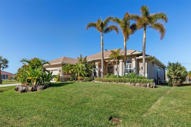 single story home featuring a front yard and a garage