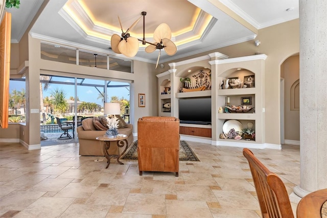 living room featuring a chandelier, crown molding, a tray ceiling, and built in features