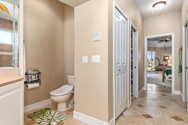 bathroom featuring toilet, a healthy amount of sunlight, vanity, and ceiling fan