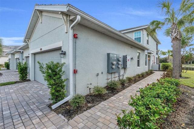 view of side of property featuring a garage and cooling unit